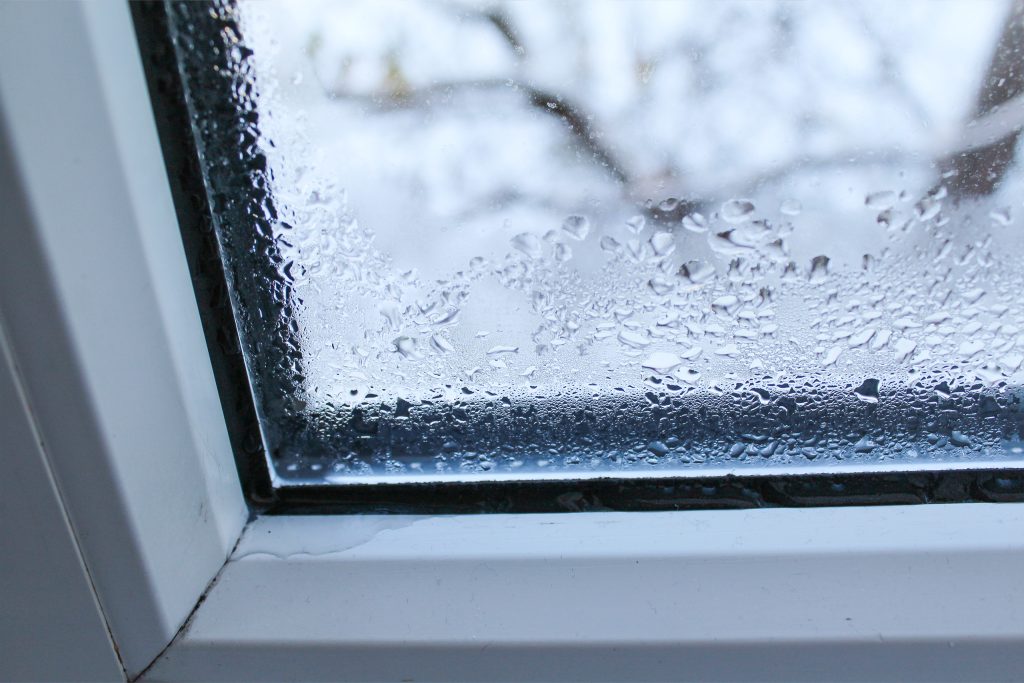 Nahaufnahme eines Fensterrahmens mit Kondenswasser im Winter