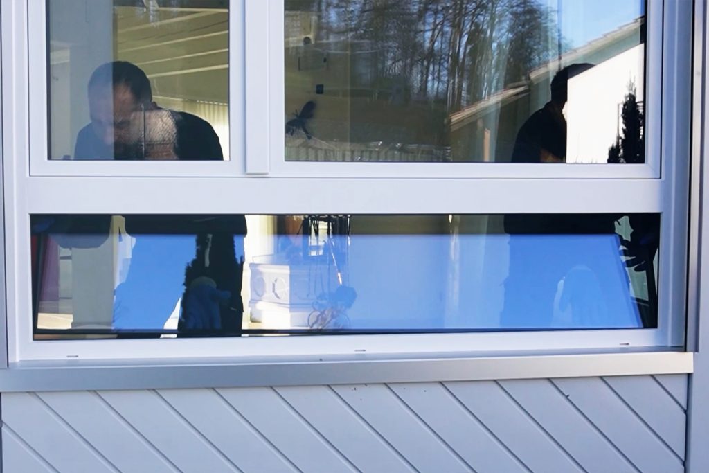 Fensterersatz bei der Sanierung – Mitarbeiter montieren neues Fenster in einem Wohnhaus von außen sichtbar